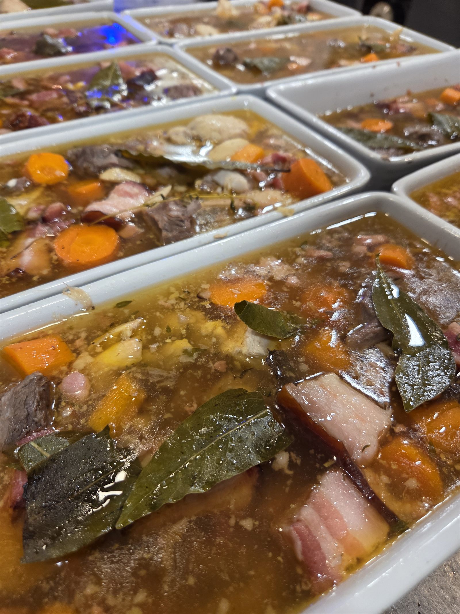 Potjevleesch en cours de cuisson dans une grande poêle en cuivre, viandes du Nord et tranches de pain d'épices dossées par-dessus, classique flamand préparé à l'ancienne au Georges V